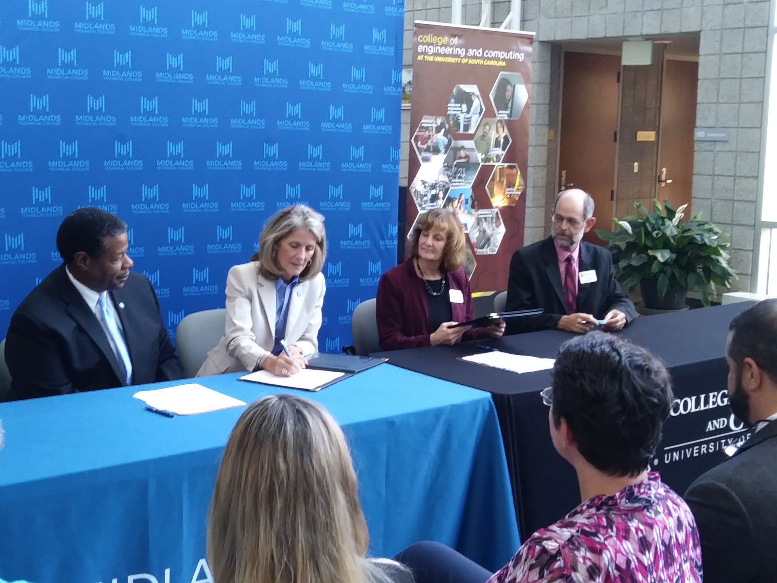 Midlands Technical College President Ronald Rhames (from left) and provost Barrie Kirk; Sandra Kelly, vice provost and dean of undergraduate students at the University of South Carolina; and Jed Lyons, associate dean of academic affairs at USC, sign a transfer agreement. (Photo/Travis Boland)