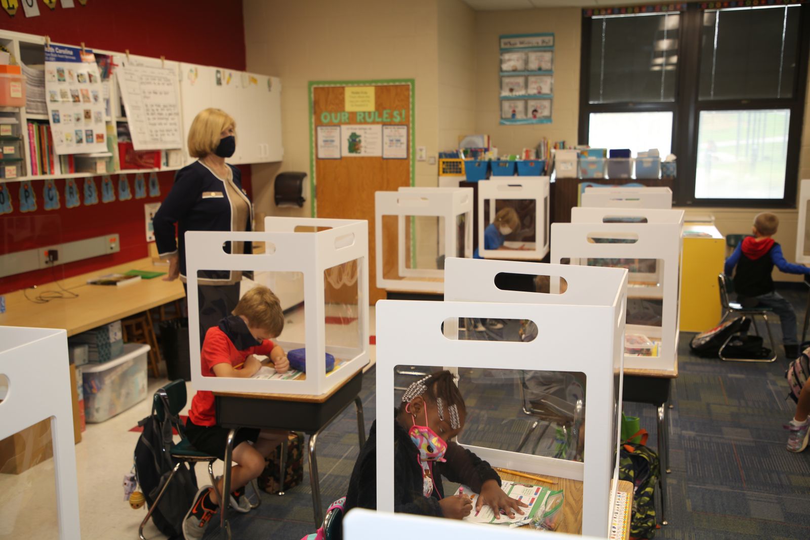 Education superintendent Molly Spearman stands by as students try out new plexiglass dividers. (Photo/Provided)