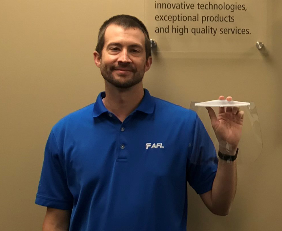 Applications engineering manager holds a faceshield he helped developed. (Photo/Provided)