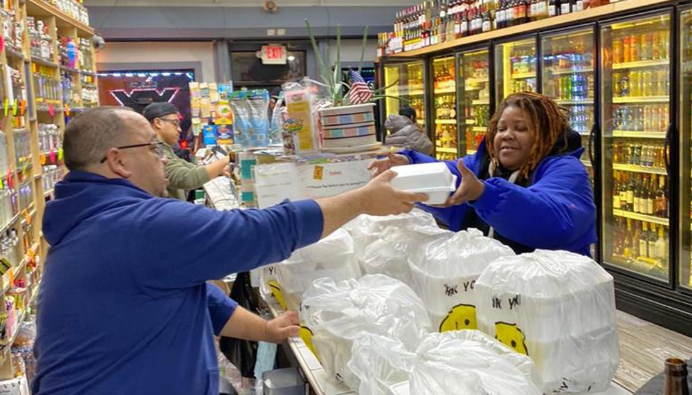 Amin Arias hands out free meals to customers of his liquor store in Trenton, N.J. (Photo/Latino Merchant Association of New Jersey)