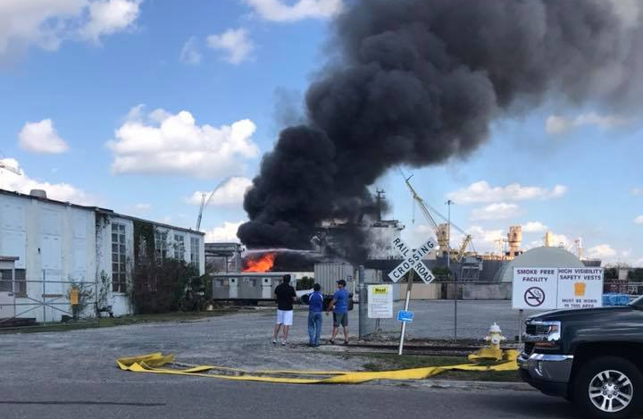 Bystanders watch as an old warehouse burns today on the former Navy Base in North Charleston. (Photo/Adam Randall)