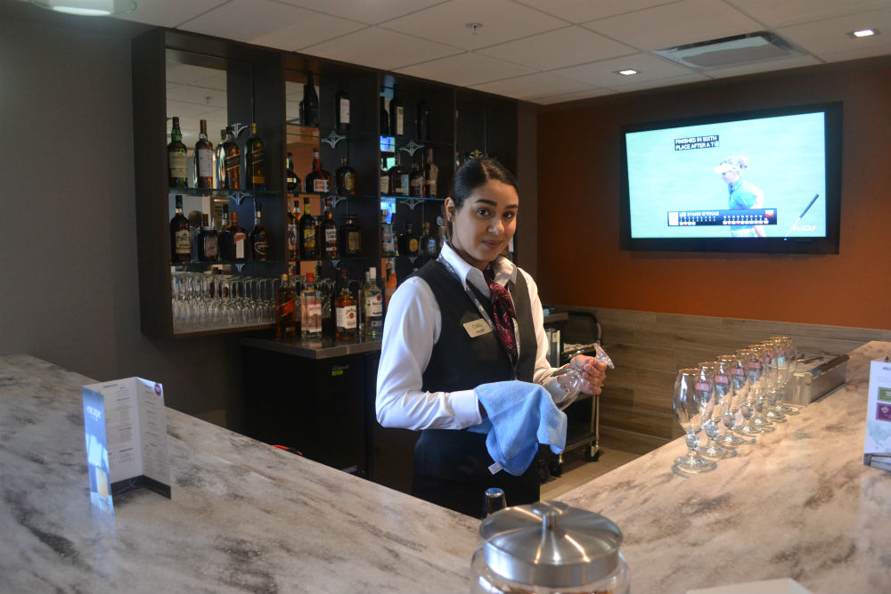 Celia Betha, lounge agent, takes care of customers from behind the bar at Escape Lounge. (Photo/Ross Norton)