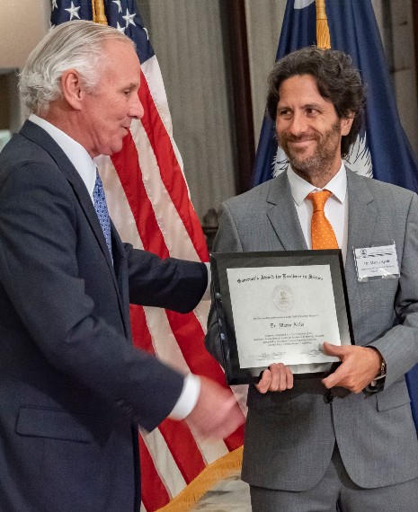 Gov. Henry McMaster, left, presents the 2021 Governor‰ŰŞs Young Scientist Award for Excellence in Scientific Research to Marco Ajello. (Photo/Provided)