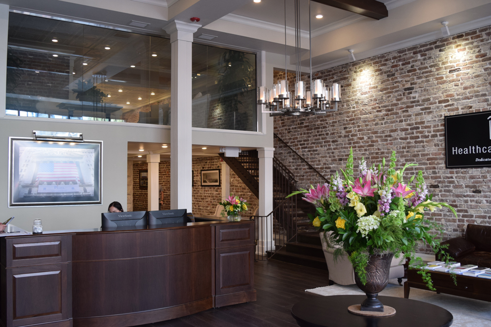 During renovations completed in 2016, Healthcare Trust of America Inc. uncovered some of the original brickwork of 39 Broad St. and transformed the first floor of the building from a retail space into an office. (Photo/Patrick Hoff)