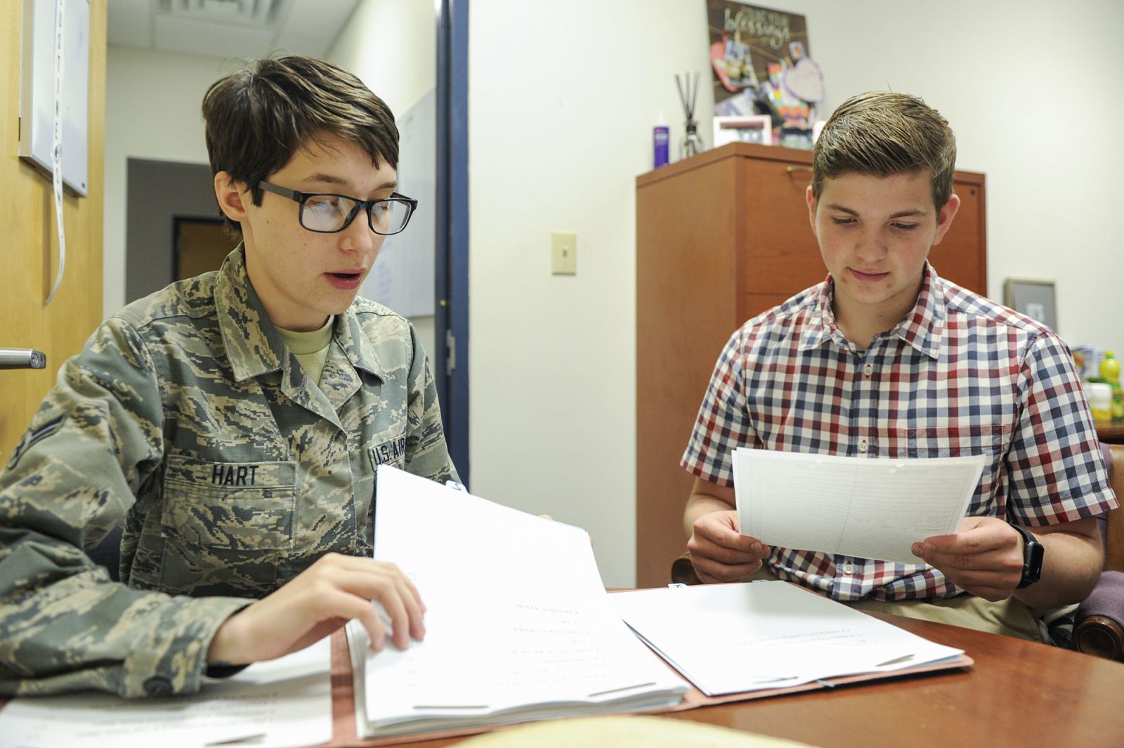 Airman 1st Class Jamie Hart, a contract specialist assigned to the 628th Contracting Squadron, goes over the procedures for reviewing a contract with Aleric Stell, a summer intern at Joint Base Charleston. (Photo/Senior Airman Thomas T. Charlton for the Air Force)
