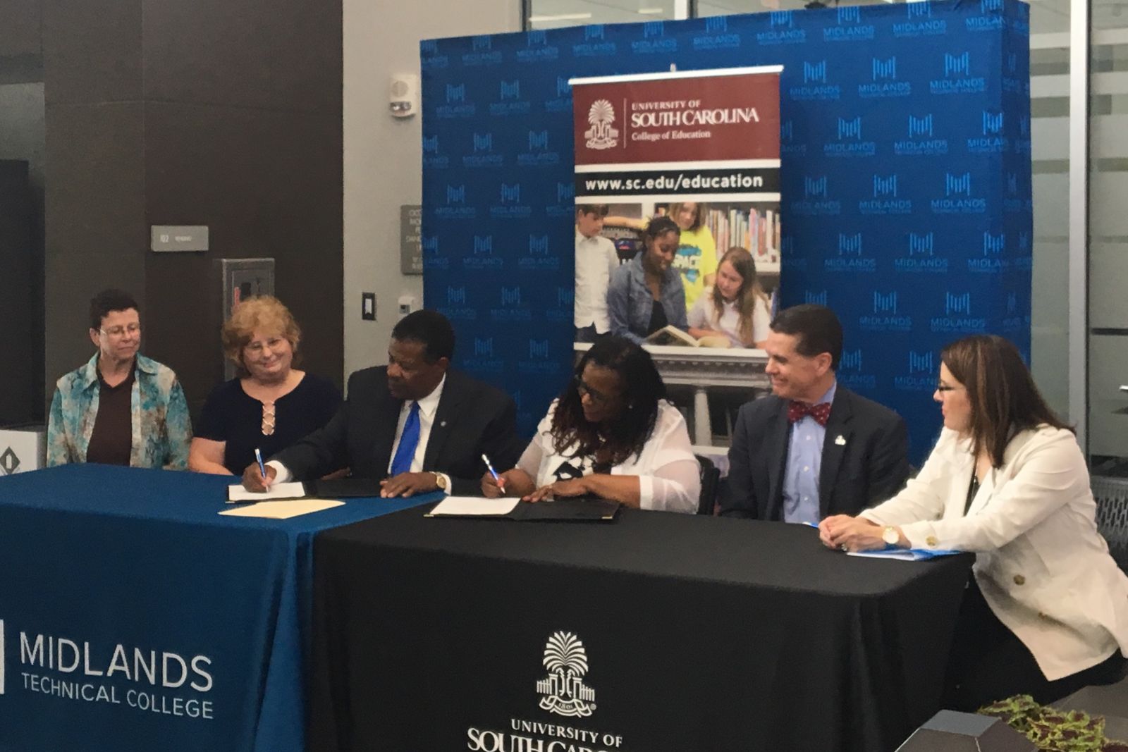 Officials from the University of South Carolina and Midlands Technical College, including MTC president Ron Rhames (third from left), sign an agreement to streamline the transfer process for MTC graduates looking to pursue an education degree at USC. (Photo/Melinda Waldrop)
