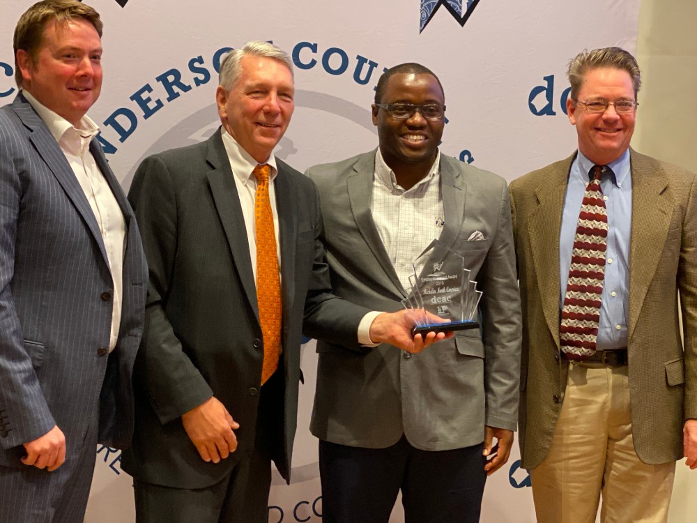 Burriss Nelson, president of the Development Corp. of Anderson County and director of economic development for Anderson County, presents Michelin with an Employer Impact Award. Pictured, from left, Jonathan Wright, Burriss Nelson, Cauiss Holmes and Steve Miles. (Photo/Teresa Cutlip)