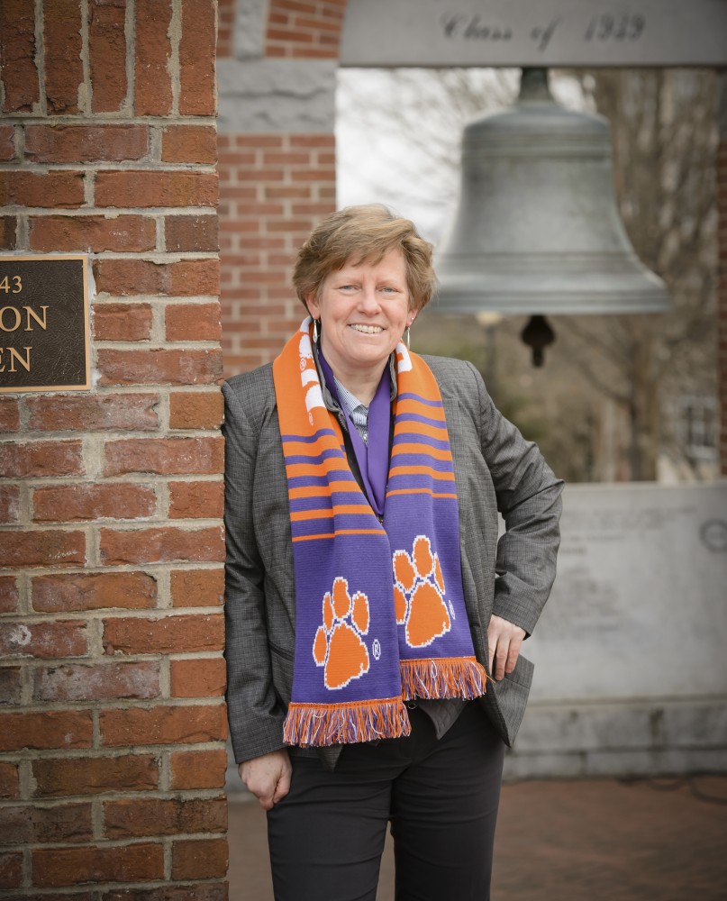 June Pilcher stands in front of the Class of ‰ŰŞ39 bell in Clemson's Carillon Garden. (Photo/Provided)