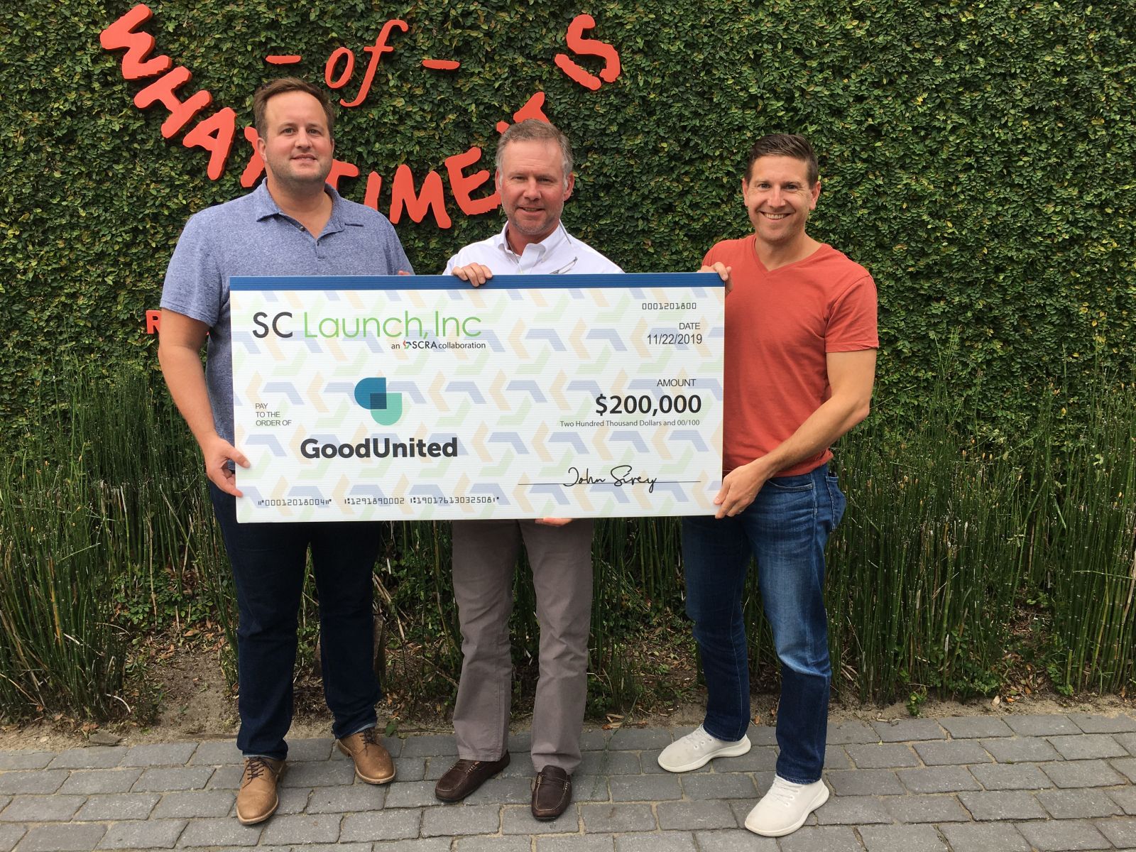 GoodUnited CEO Nick Black (from left), SCRA Investment Manager Derek Willis and GoodUnited President Jeremy Berman pass the ceremonial big check for the SC Launch investment in the startup. (Photo/Provided)