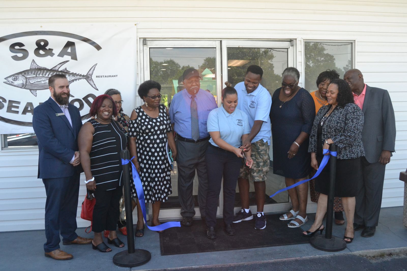 S&A Seafood celebrated the opening of a new location in North Columbia with a ribbon cutting on Friday. Co-owners Davant and Delilah Jenkins (center, with scissors) opened their first restaurant and market in Blythewood seven years ago. (Photo/Travis Boland)