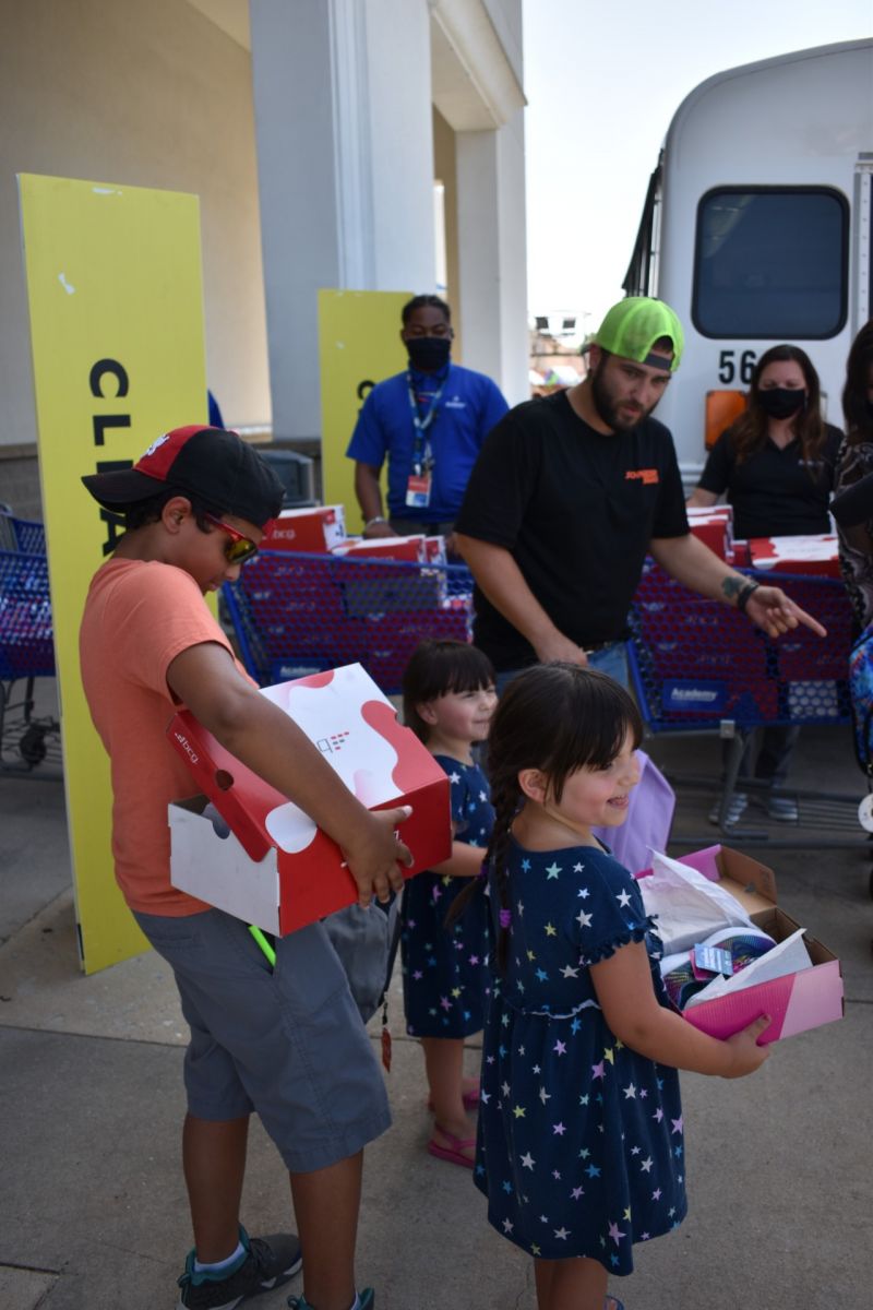 One of the families served by the YMCA meal program is presented with shoe boxes and backpacks. (Photo/Molly Hulsey)