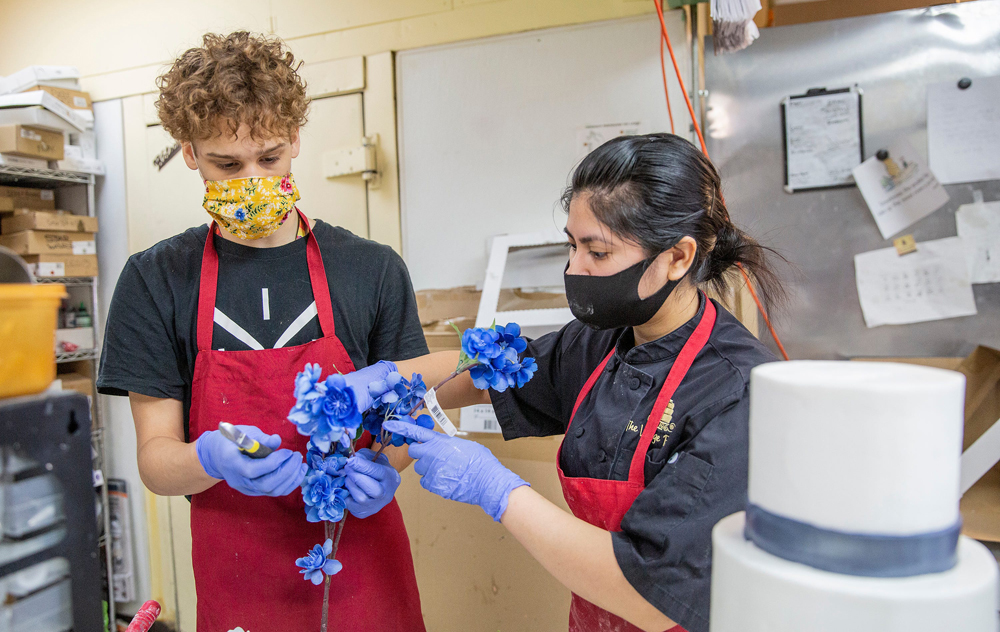 Krishna Potaraju (left) who recently got a summer job working at The Village Bakery, cuts flowers for cake director Nikki Ortega in Houston on June 5. (Photo/Thomas B. Shea for USA Today)