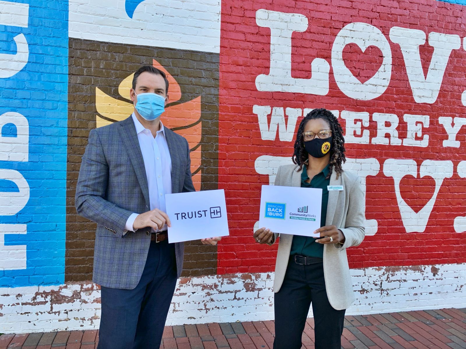 Representatives from Truist and CommunityWorks pose in front of a mural at Spartanburg's Morgan Square. (Photo/Provided)