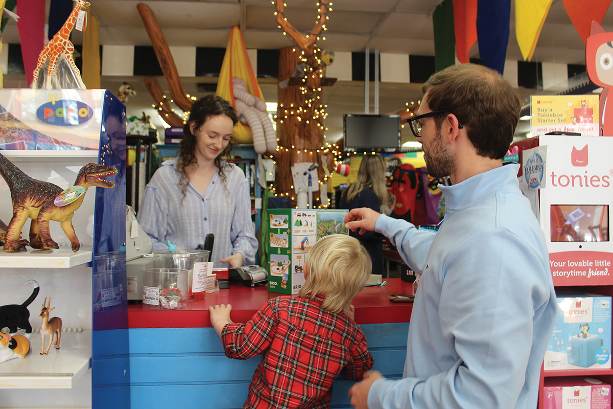 Be Beep A Toy Shop sales associate Ally Sundius rings up a purchase for Drew Lewis and dad Andrew Lewis at the toy store in Forest Acres. (Photo/Christina Lee Knauss)