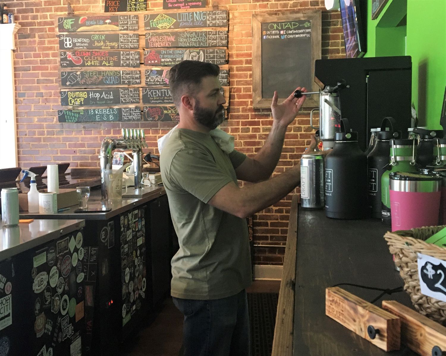Craft and Draft co-owner Kellan Monroe fills a to-go crowler for a customer on Thursday afternoon. (Photo/Melinda Waldrop)