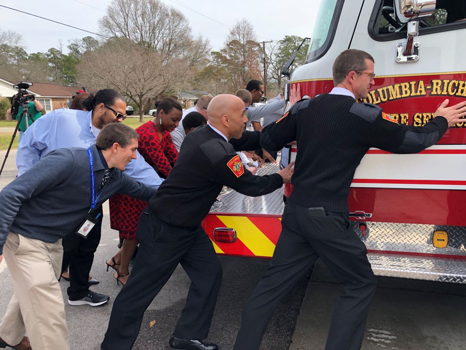 Richland County officials and firefighters with the Columbia-Richland County Fire Department help push a new firetruck into the bay at Capitol View Station on Monday. (Photo/Provided)