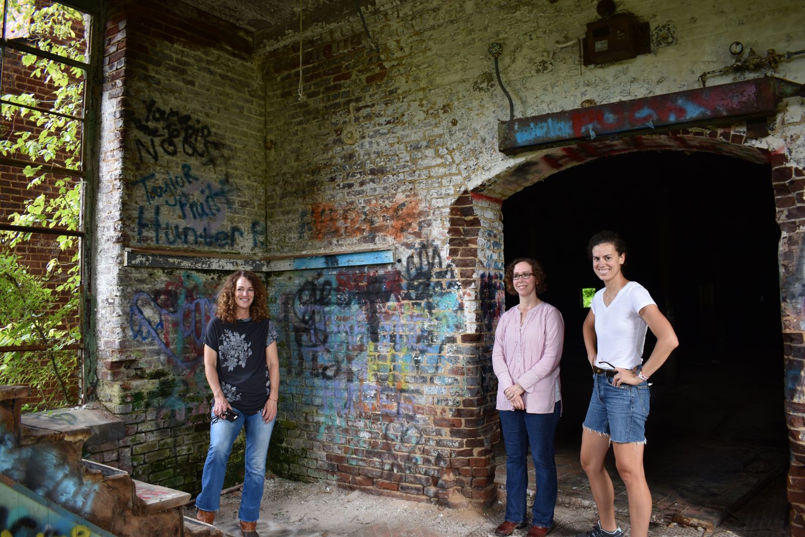 M. Pters Group partner Jennifer Gosnell, Melanie Peters and Maggie Law, asset manager for the company, survey the mill's tower, which will undergo extensive rehabilitation. (Photo/Molly Hulsey)