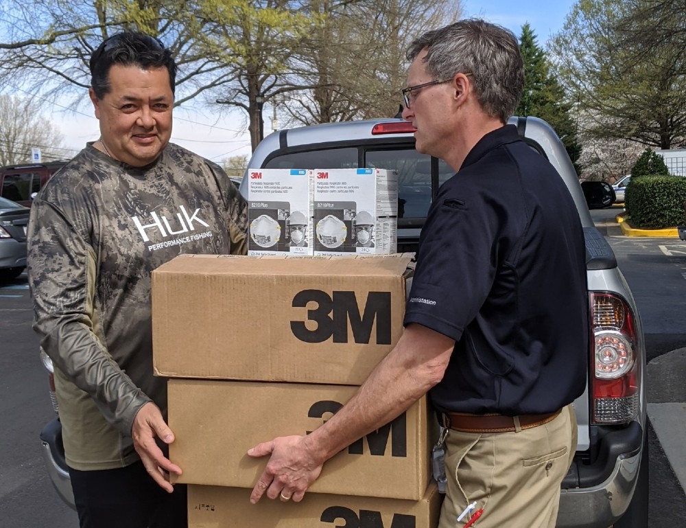 Spartanburg Regional CEO Bruce Holstien (left) and David Church, vice president of oncology and support services at Spartanburg Regional Healthcare System, carry some of the donated items into the hospital. (Photo/Provided)