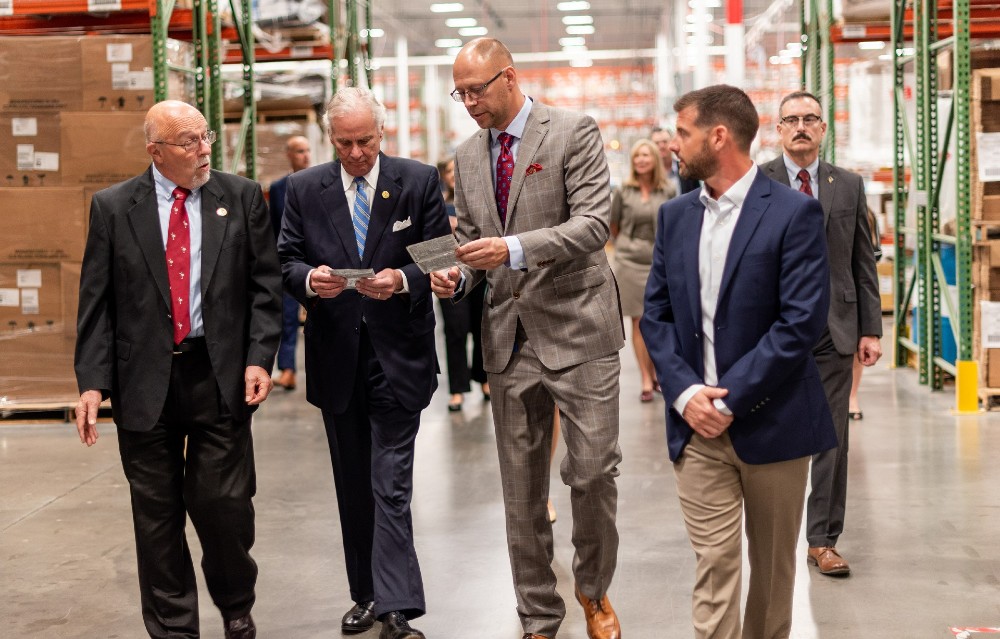 Gov. Henry McMaster, second from left, examines surface disinfectant wipes manufactured at Multi-Pack Solutions in Greenville. Company CEO John Niemi, center, and Ryan Strange, director of operations, right, led the governor on a tour of the medical contract manufacturers‰ŰŞ facilities and discussed plans for expansion. They were joined by Lynn Ballard, left, a member of Greenville County Council. (Photo/Provided)