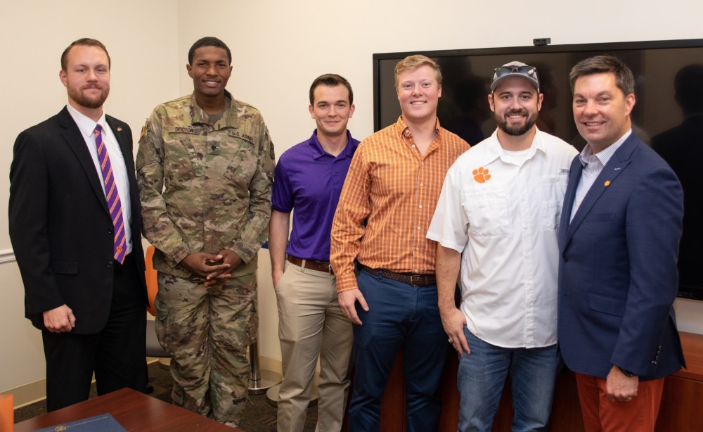 Brennan Beck (left), director of military and veteran engagement at Clemson, with Newport News Shipbuilding scholarship recipients Daquan Doctor, who serves in the Army National Guard; Damion Anderson, who served in the Marine Corps; Giff Finley, who served in the Coast Guard; and Stewart Fuller, who is on active duty with the Navy. At right is alumnus Matt Needy, who is the company??s vice president of operations.