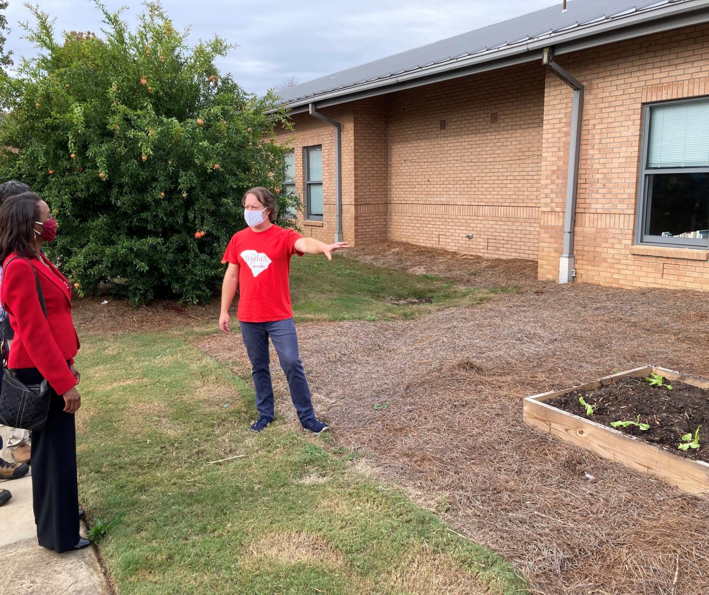 Jamison Browder shows off garden beds used to teach students about gardening and conservation at Meadowfield Elementary School as Richland County Councilwoman Chakisse Newton looks on. (Photo/Provided)