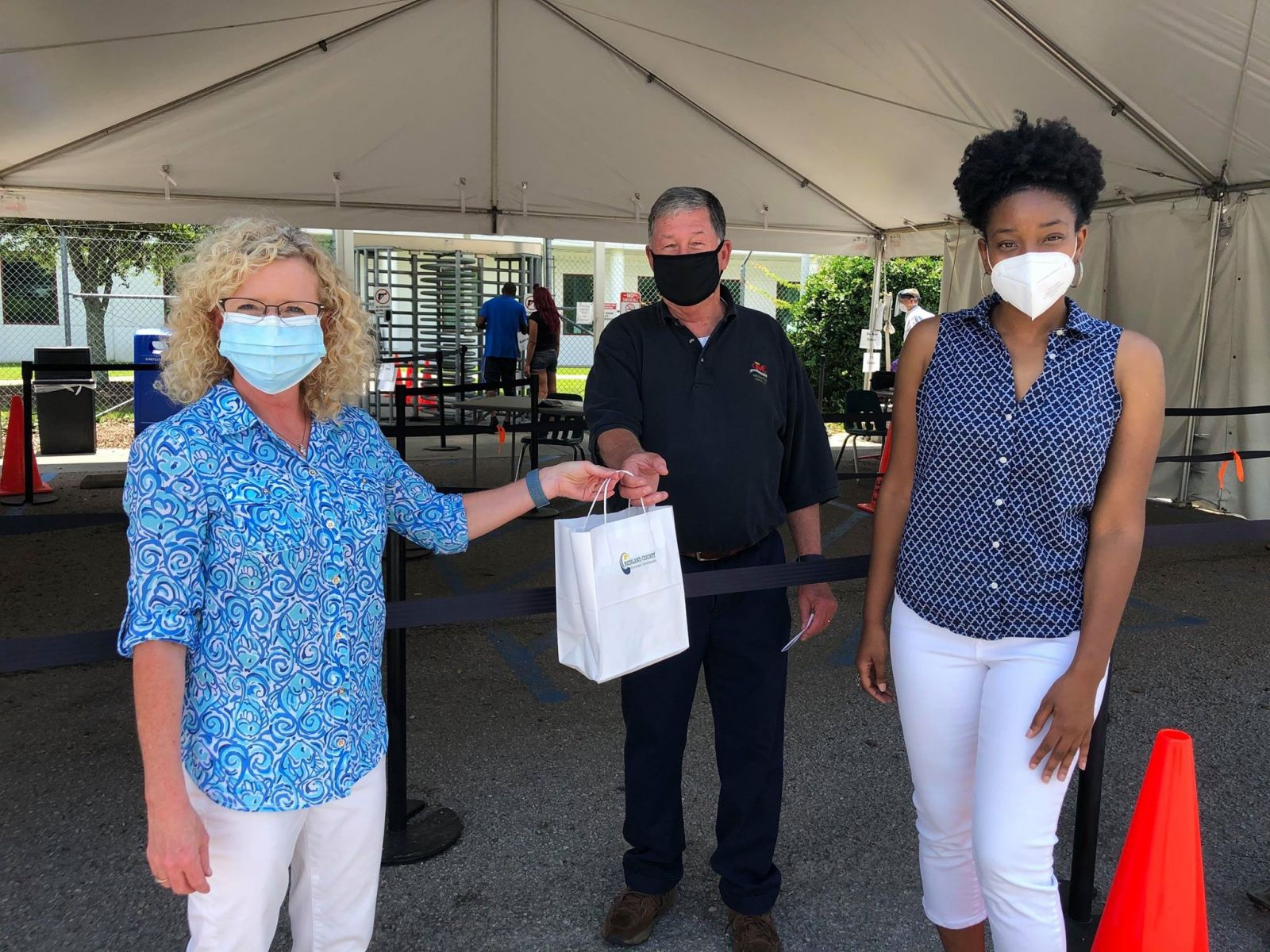 Kim Mann and Mariah Washington of Richland County Economic Development deliver noncontact infrared thermometers to Jay Metts of McEntire Produce. (Photo/Provided)