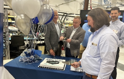 Jeff Baldwin, director of engineering for Sealevel Systems Inc., cuts a cake to celebrate the event. (Photo/Ross Norton)